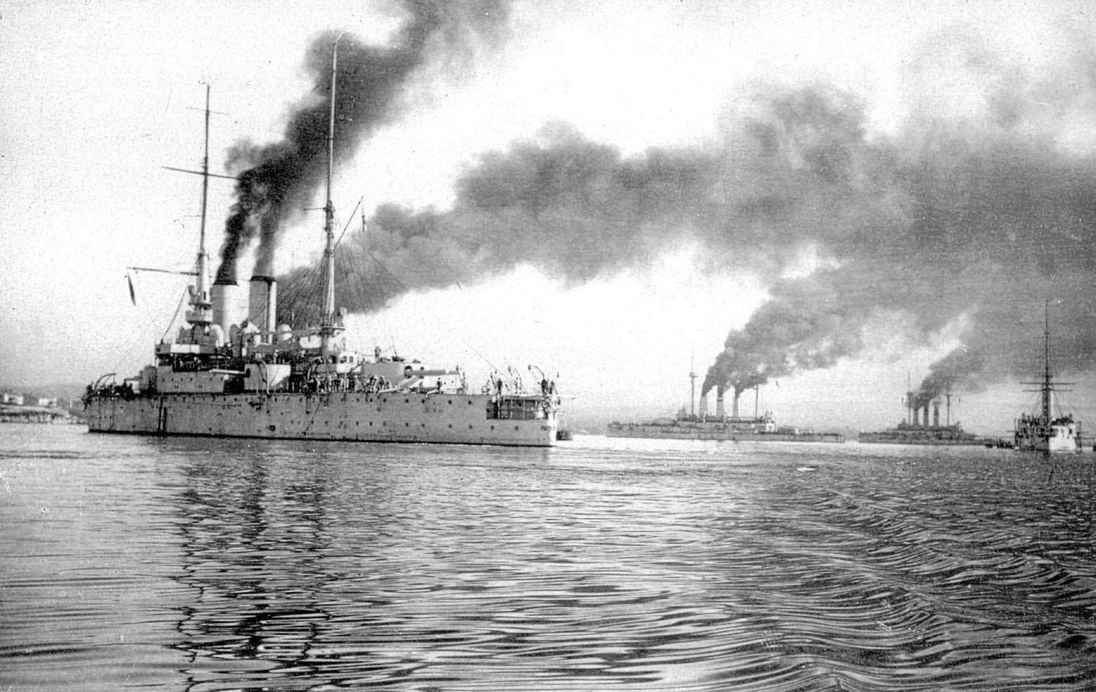 Эскадра броненосцев на выходе в море, корабли идут под парами, густой дым из труб